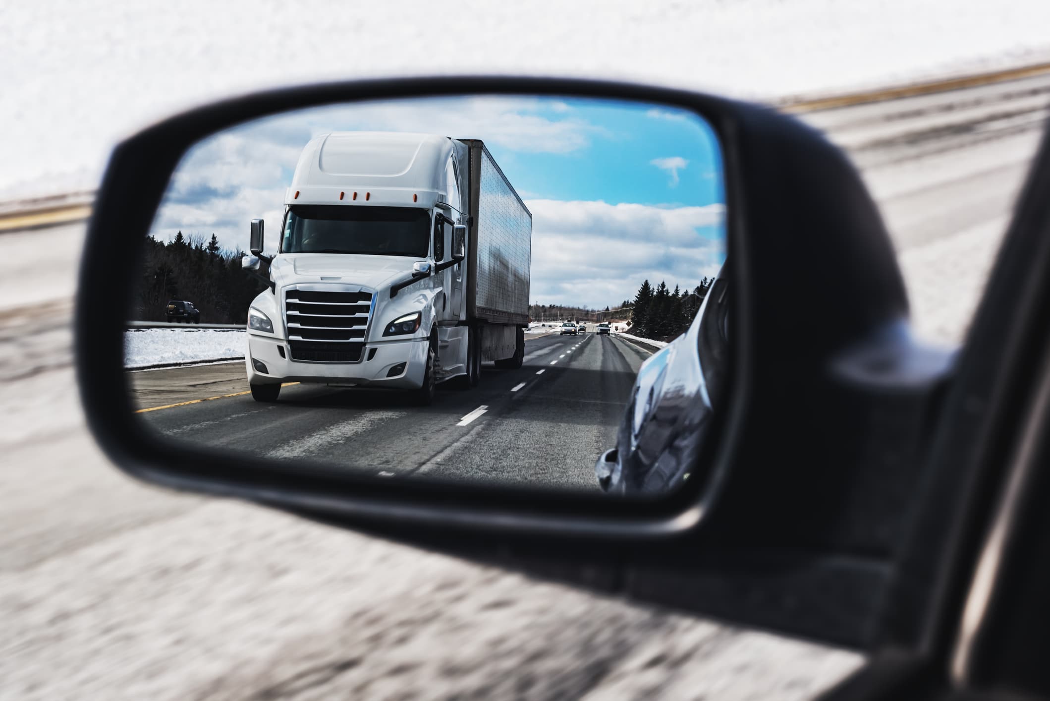 white semi-truck in rear view mirror, bakersfield truck accident lawyers